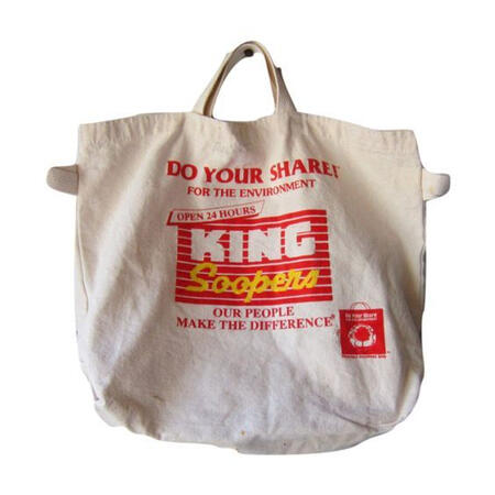A cloth shoppng bag with red text on it.
